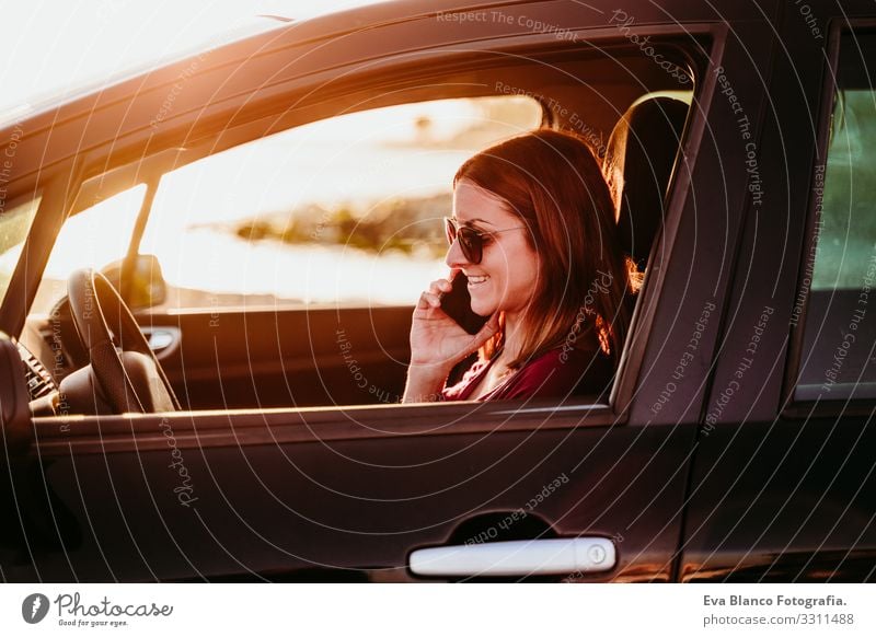 young woman driving a car at sunset and using mobile phone. travel concept Youth (Young adults) Woman Car Driving Sunset Beach Driver Vacation & Travel
