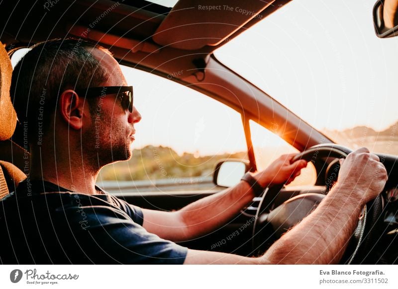 young man holding wheel and driving at sunset. travel concept Man Driving Car Sunset Street Vacation & Travel Trip Caucasian Youth (Young adults) Driver