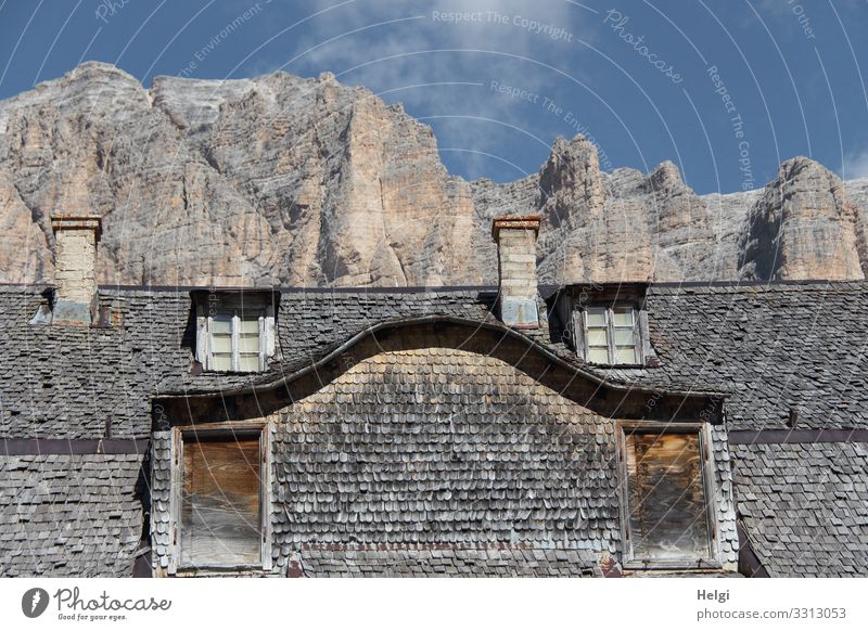 old house clad with wooden shingles stands in front of a gigantic mountain in the Dolomites Environment Nature Sky Clouds Autumn Beautiful weather Rock Alps