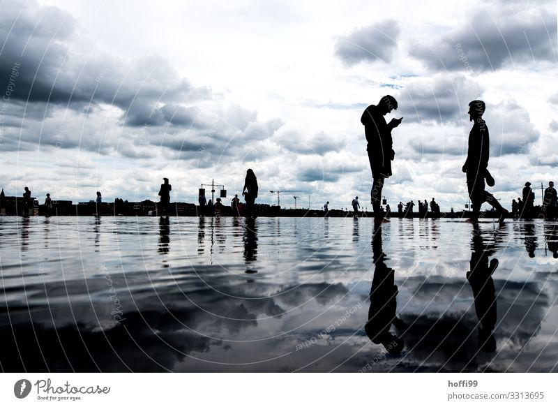 Silhouette of people reflected on a surface of water Cellphone Human being 2 18 - 30 years Youth (Young adults) Adults Water Sky Clouds Climate Bad weather