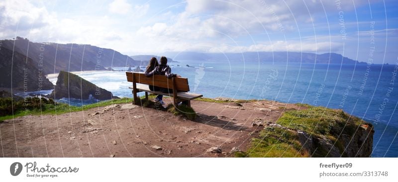 Panoramic view of a couple in the best bench of the world panoramic landscape Loiba Galicia natural summer water nature beautiful island fishing grow green