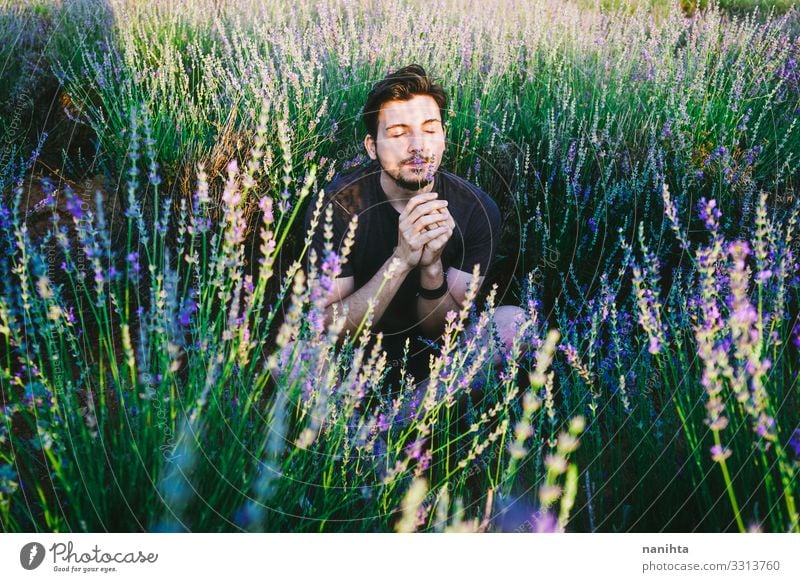 Young man in a field of flowers masculinity new gender handsome spring shadow light sun sunny lavender male young beard bearded casual wear natural real
