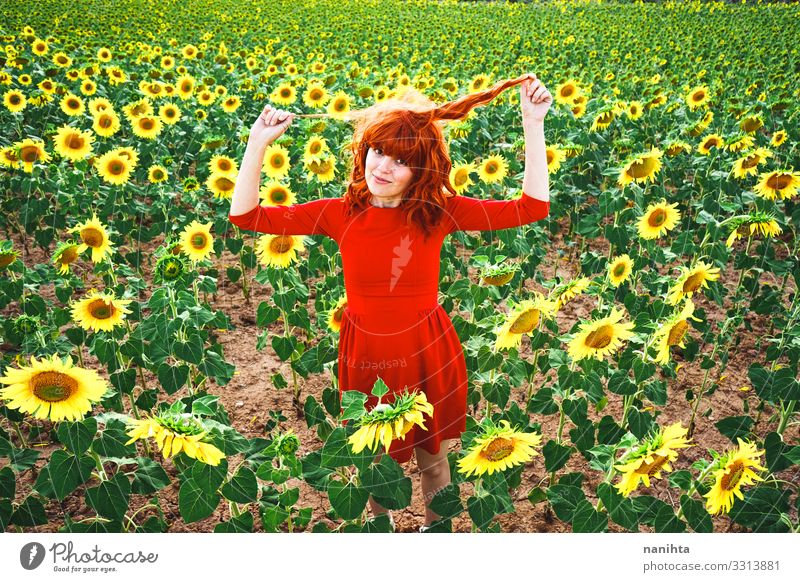 Lovely redhead woman enjoying the day in a field o sunflowers happiness spring young freedom life summer holidays fun funny candid real real people lifestyle