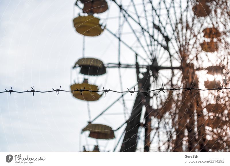 barbed wire and carousel in amusement park in Chernobyl Vacation & Travel Tourism Trip Plant Sky Autumn Tree Park Metal Old Threat Blue Yellow Dangerous
