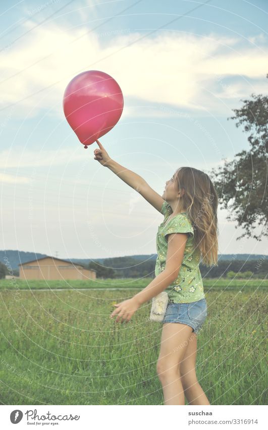 girl plays with a red balloon Child Infancy Playing Balloon Exterior shot Joy Summer Grass Nature Happiness Meadow Leisure and hobbies rural cheerful fortunate