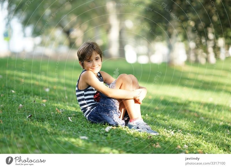 Little girl, eight years old, sitting on the grass outdoors. Style Joy Happy Beautiful Face Playing Vacation & Travel Freedom Summer Child Schoolchild