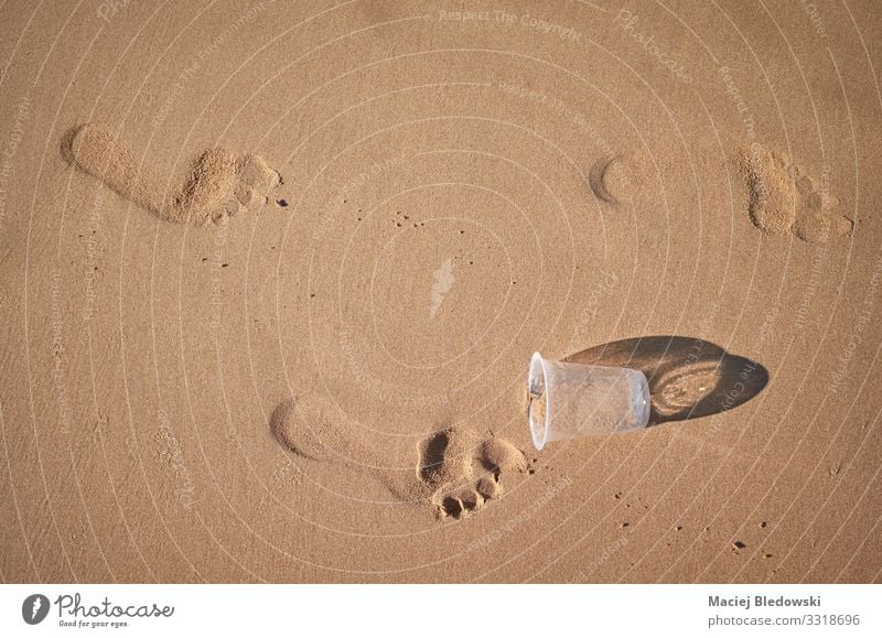 Footprints and plastic cup on a sandy beach. Lifestyle Vacation & Travel Tourism Summer vacation Beach Environment Nature Sand Plastic Environmental pollution
