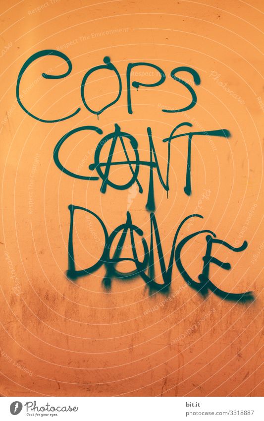 The police can't dance, it's written as writing on an orange wall. Ironic sign against police, for anarchy with anarchy cakes sprayed on wall. Symbol for anarchism, politics without power, leftists, freedom and left-wing movement.