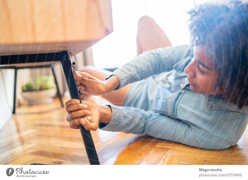 Afro woman repairing furniture at home. Lifestyle House (Residential Structure) Furniture Work and employment Tool Woman Adults Hand Cleaning Repair