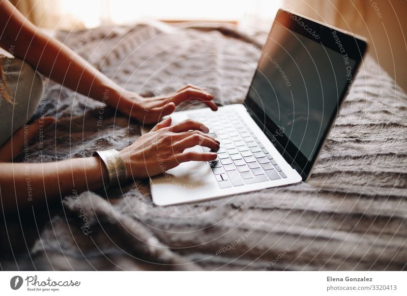 Woman's hands typing on laptop keyboard in the cozy bedroom. Lifestyle Academic studies Work and employment Profession Workplace Office Financial Industry