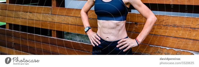 Cheerful female athlete in front of a wooden background Lifestyle Body Sports Internet Human being Woman Adults Brunette Fitness Stand Athletic Authentic Thin