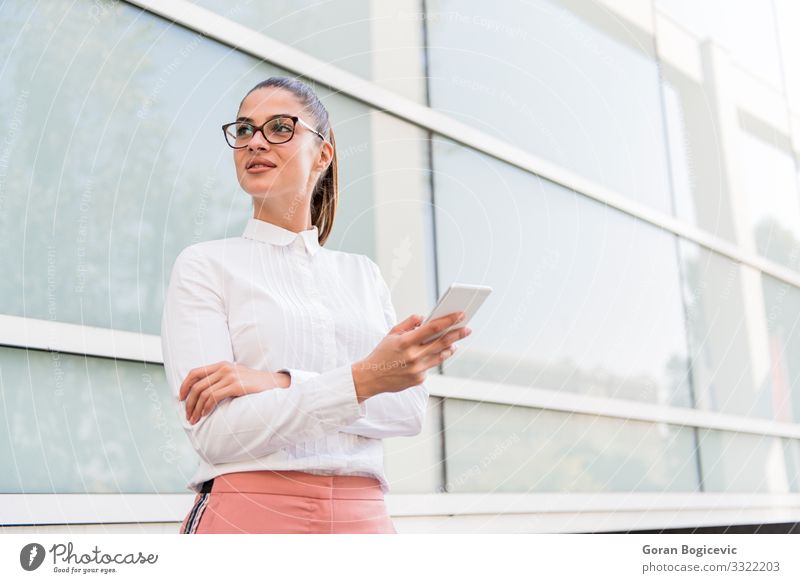 Portrait of young businesswoman using mobile phone on a break at outdoor Lifestyle Beautiful Relaxation Work and employment Business Telephone PDA Technology