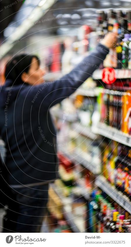 Woman looks at the goods on a supermarket shelf Shopping Trolley Food Supermarket Colour photo Consumption Store premises Human being consumer by hand