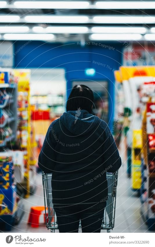 Woman walks through the store with the shopping cart Shopping Trolley Food Supermarket Colour photo Consumption Store premises Human being consumer by hand