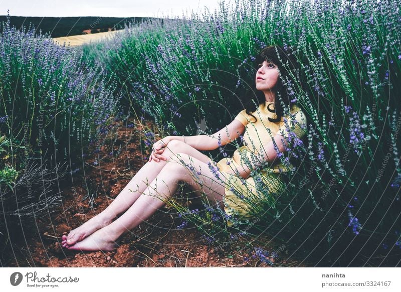 Young brunette woman sitting surrounded by lavender young pretty retro vintage nature natural real candid relax tranquility scene flowers spring springtime