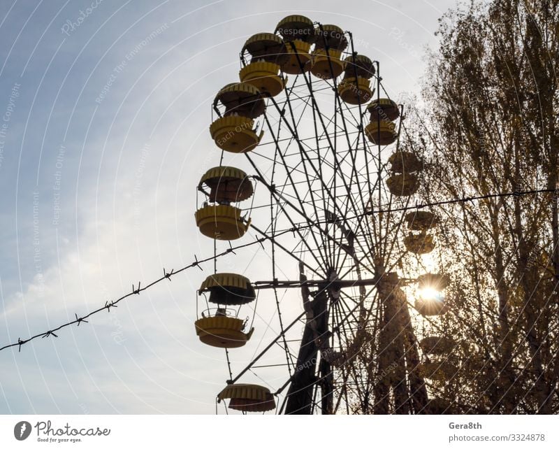 barbed wire and cabins carousel wheel in Chernobyl Vacation & Travel Tourism Trip Plant Sky Autumn Tree Park Metal Old Threat Blue Yellow Dangerous Disaster