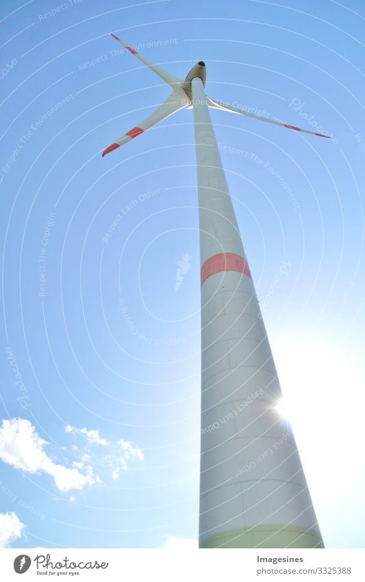 Wind turbine against a blue sky with sun and clouds, Rhineland-Palatinate, Germany. alternative energy, new natural landscape Wind energy plant Blue sky Clouds