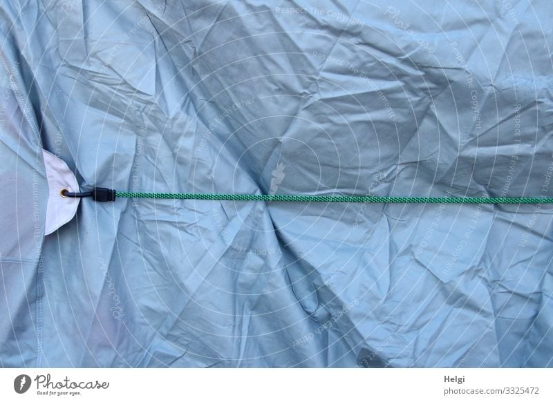 short tied | literally - light blue wrinkled plastic tarpaulin is held in place with a rubber band Rubber Elastic band stop To hold on connected crease