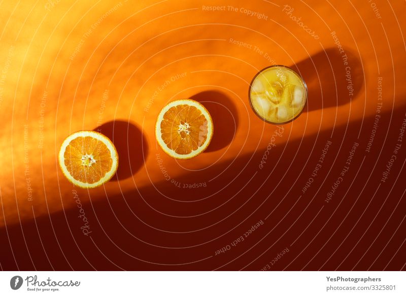 Cold orange juice glass and orange cut in half in sunlight Fruit Orange Breakfast Beverage Cold drink Glass Fresh above view citrous Citrus fruits colorful