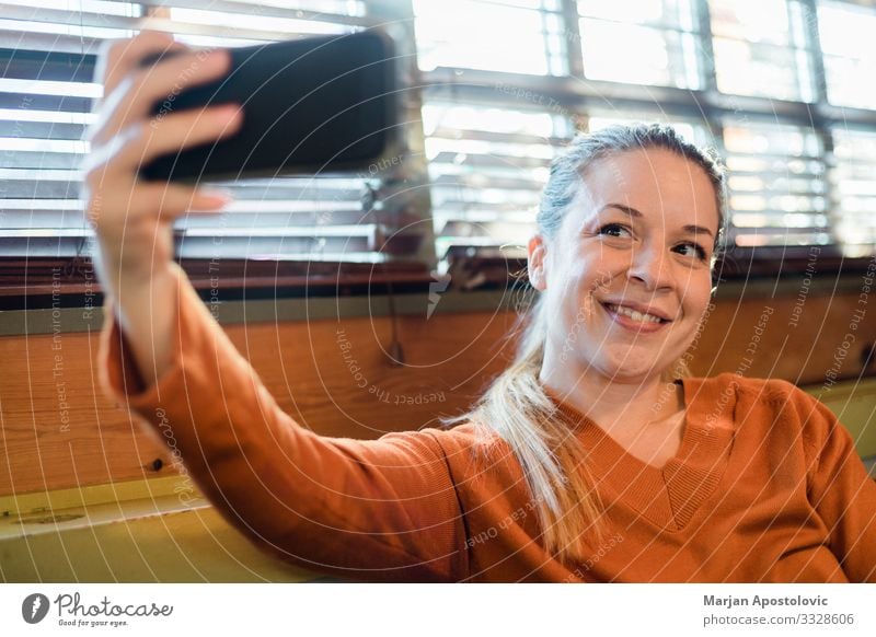 Young woman taking a selfie indoors by the window Lifestyle Joy Cellphone Camera Technology Telecommunications Internet Feminine Youth (Young adults) Woman