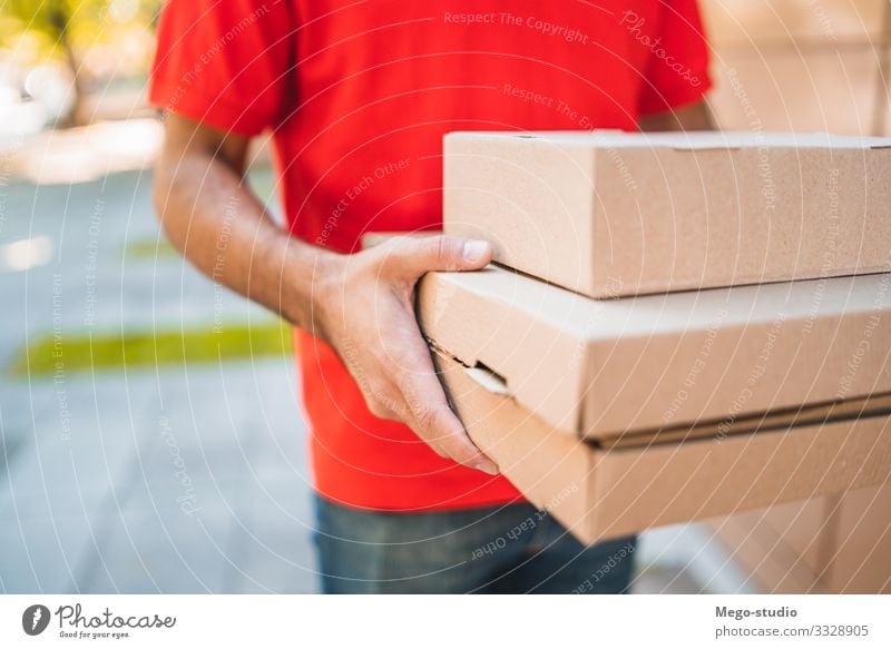 Delivery man carrying packages while making home delivery. Work and employment Profession Craftsperson Office Industry Business Human being Man Adults Hand 1