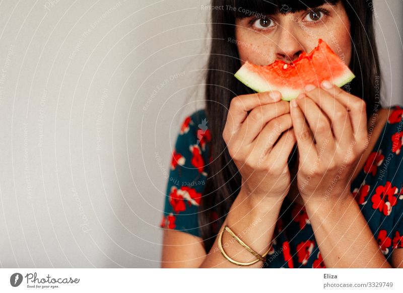 A woman holds a bite of watermelon in front of her face. Vegan and healthy food. Human being Feminine Young woman Youth (Young adults) Woman Adults 1