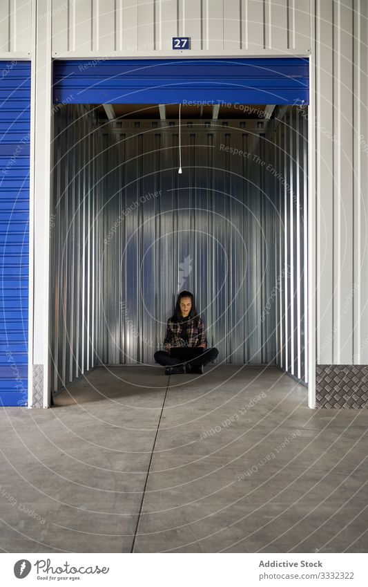 Woman sitting at self storage floor woman package warehouse packing cargo delivery transportation move work relocating packet moving unpacking business