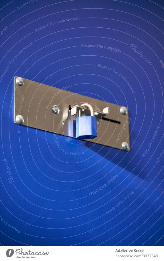 Blue padlocks on a blue door secure safety security protection private safeguard metal object secured privacy access secret key protected steel shadow ground