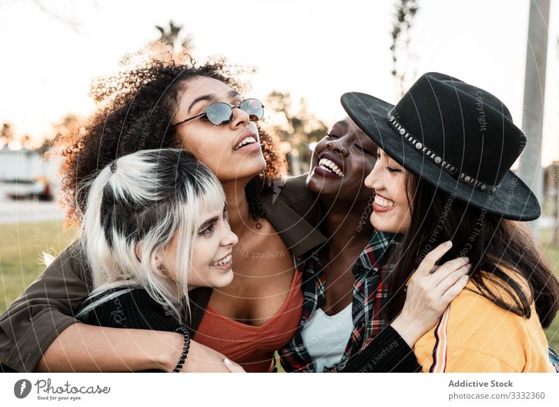 Multiethnic group of female hipsters cuddling with each one young style smile hug portrait together friend diverse multiracial multiethnic hugging laughing