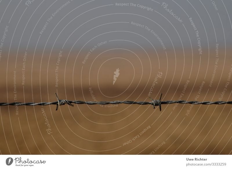 Barbed wire in front of blurred fields Agriculture Forestry Landscape Field Beginning Loneliness Apocalyptic sentiment Frustration Threat Horizon