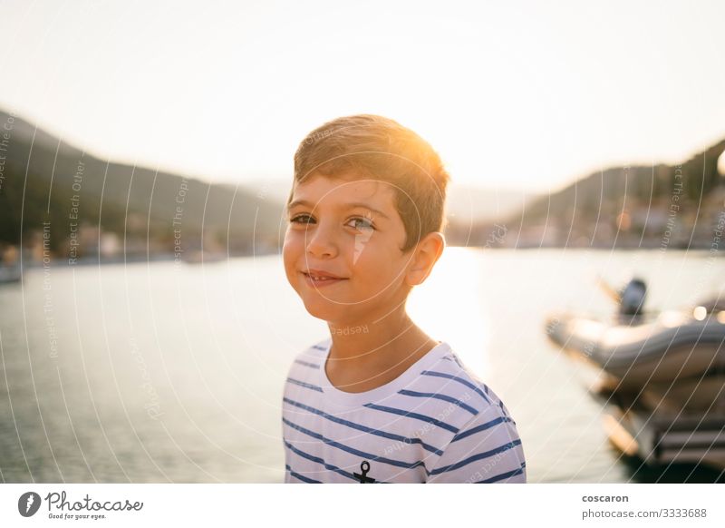 Cute kid smiling at sunset with the sea in the background Lifestyle Joy Happy Beautiful Face Vacation & Travel Tourism Freedom Summer Summer vacation Sun Beach