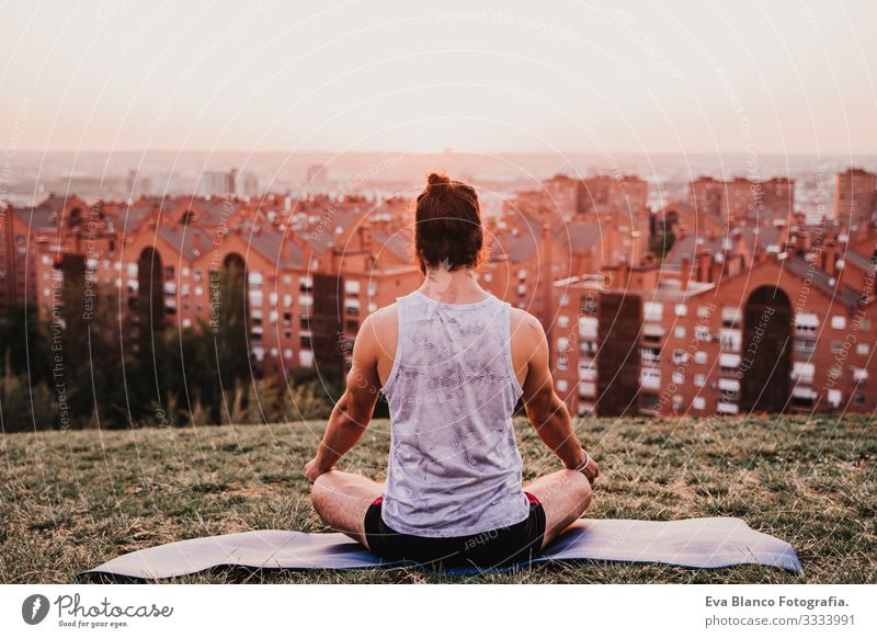 young man in a park ready to practice yoga sport. city background. healthy lifestyle. Concentrate Position Human being Youth (Young adults) Body Park Man