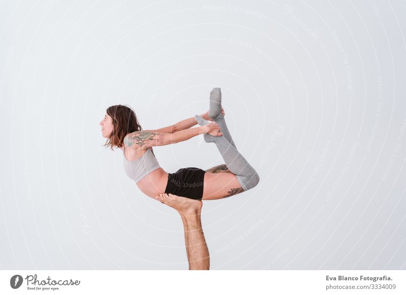 young couple Couple practicing acro yoga in white studio or gym. Healthy lifestyle Yoga Sports Gymnasium indoor Man Power Human being human relationships