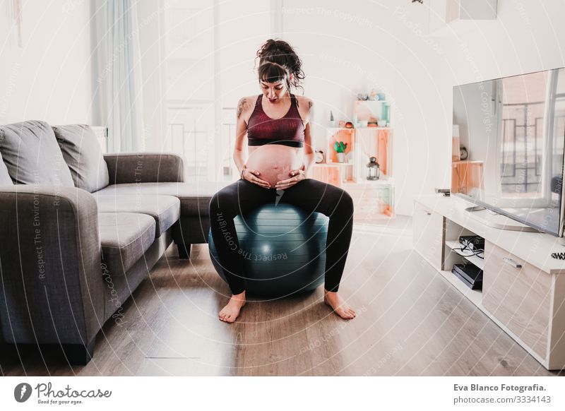 young pregnant woman at home sitting on pilates ball, healthy lifestyle Pregnant Woman Yoga Home Sports Healthy Lifestyle Youth (Young adults) Caucasian