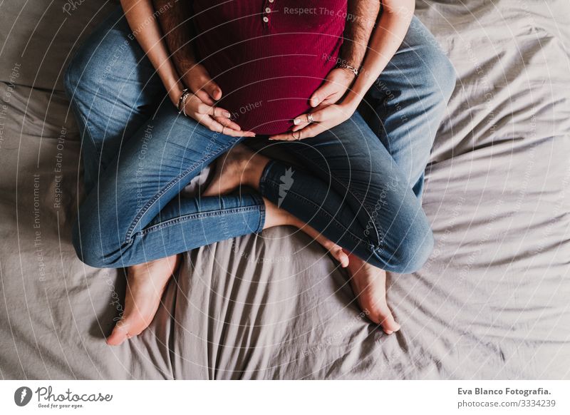 young couple at home hugging. Happy Pregnant woman smiling. top view Couple Love Woman Parents expecting Home Sofa Embrace Kissing parenthood motherhood Husband