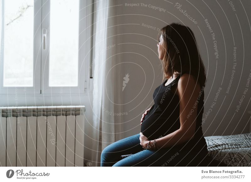young pregnant woman at home. Pregnant Woman Home Bed pregnancy Baby expecting Showing one's bellybutton Day Lie tenderness pleasure Interior design Happiness