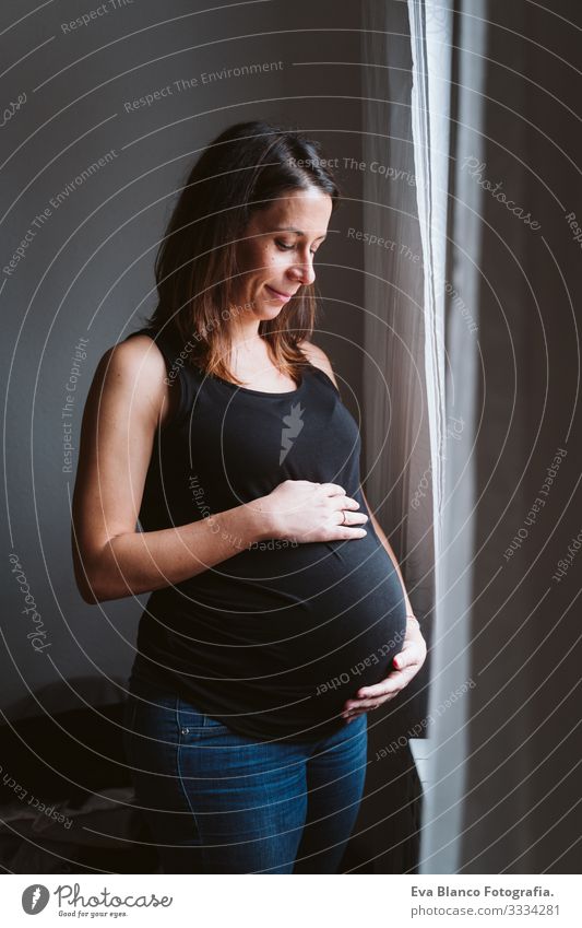 young pregnant woman at home Pregnant Woman Home Bed pregnancy Baby expecting Showing one's bellybutton Day Lie tenderness pleasure Interior design Happiness