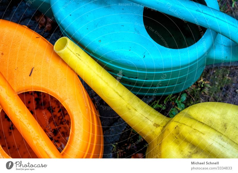 Watering cans at the cemetery Gardening Cast Work and employment Dirty Blue Yellow Orange Cemetery Colour photo Multicoloured Exterior shot Deserted Day