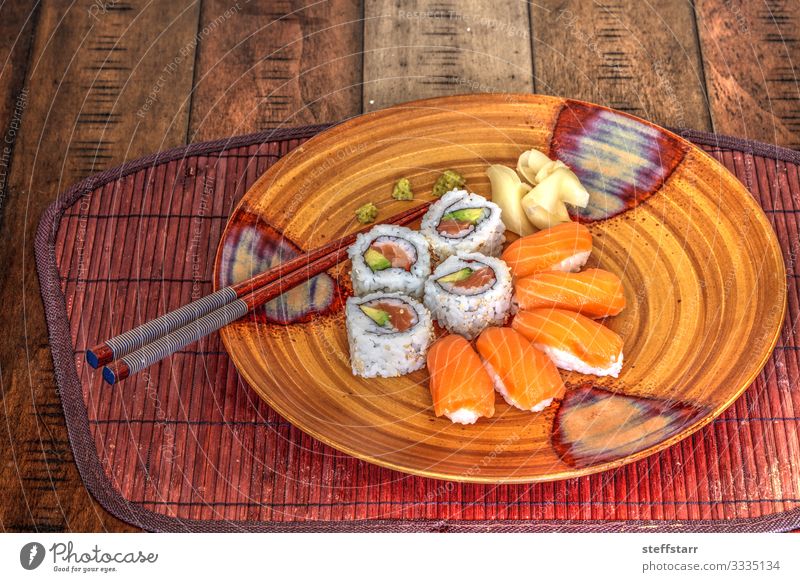 Salmon sushi rolls and sake with wasabi Food Fish Lunch Sushi Plate Healthy Eating Orange Rice wine salmon sushi raw fish Meal raw food Chopstick Wasabi ginger