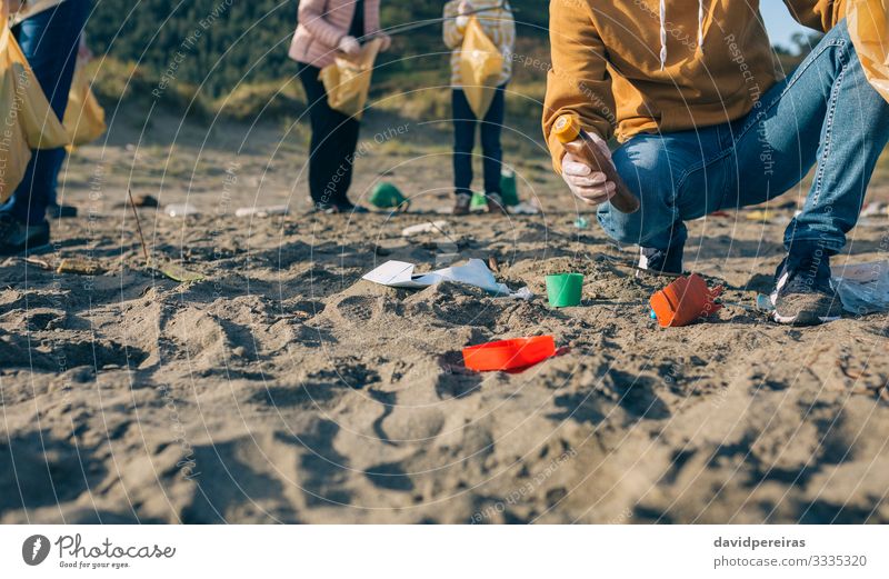 Young man cleaning the beach Beach Work and employment Human being Man Adults Family & Relations Hand Group Environment Sand Plastic Dirty Clean Teamwork