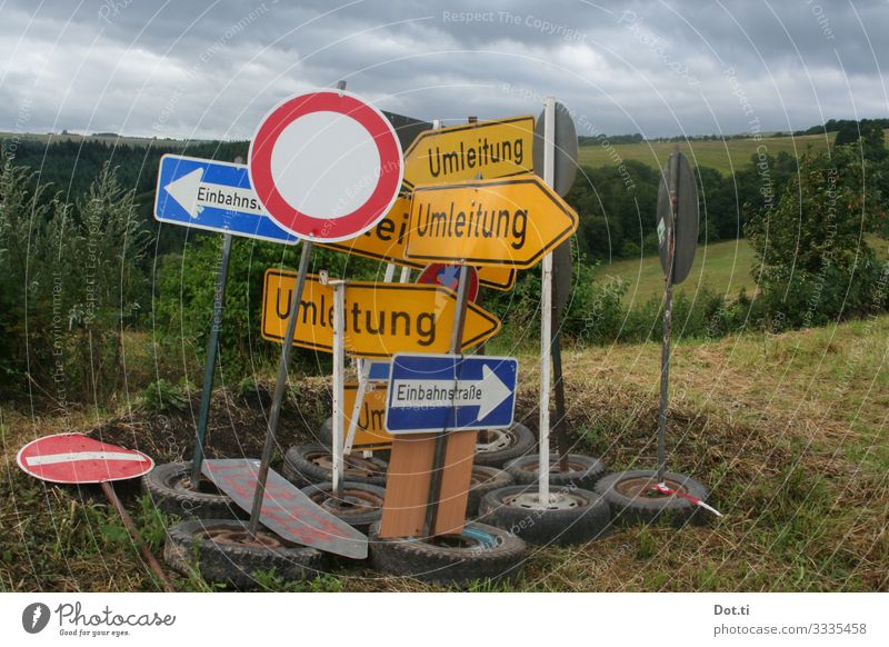 Traffic signs parked on a meadow Nature Sky Clouds Grass Field Forest Hill Transport Road sign Sign Characters Digits and numbers Signs and labeling Signage