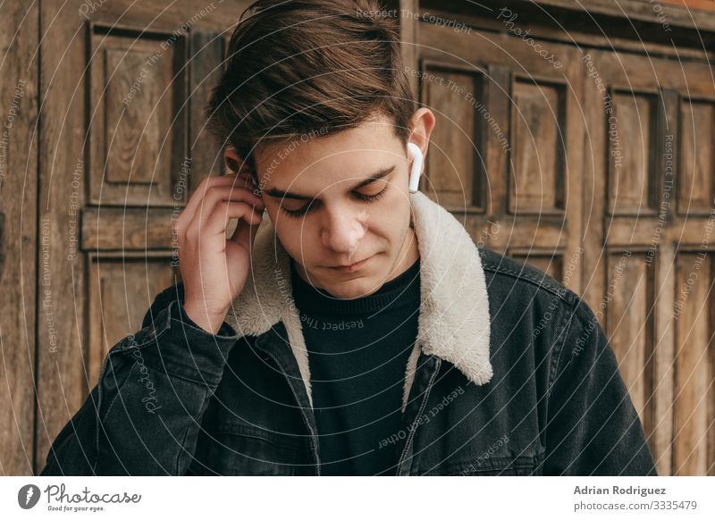 Smiling young man listen to music in modern wireless headphones