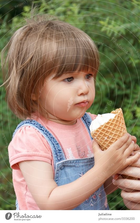 Cute girl are eating icecream Ice cream Eating Child Baby Woman Adults Park Blonde White kid European Caucasian one two three Lady short hair Vertical