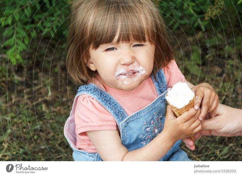 Smiling cute girl are eating icecream Ice cream Candy Eating Child Baby Woman Adults Park Blonde White kid European Caucasian one two three Lady short hair