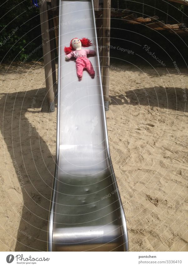 Female redheaded doll lies on a slide at the playground Leisure and hobbies Playing Summer Slide Doll Red doll clothes Feminine Playground Shadow Forget Doomed