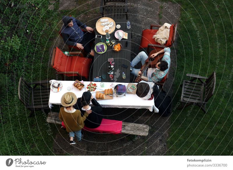 View from above of four people with picnic and guitar player at the garden table Garden table chill Together Calm fellowship Siesta Guitarist garden idyll