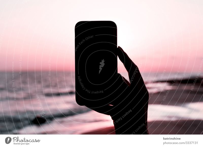 Girl is taking a sunset photo on the phone Vacation & Travel Summer Beach Ocean Cellphone PDA Technology Woman Adults Hand Environment Nature Landscape Sky Dark