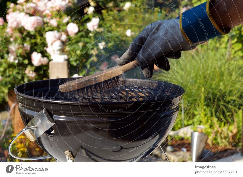 Cleaning grill. Male hand with gloves cleans round grill with brush. Preparing a grill before cooking. Man cleaning a grill in the garden BBQ Human being 1