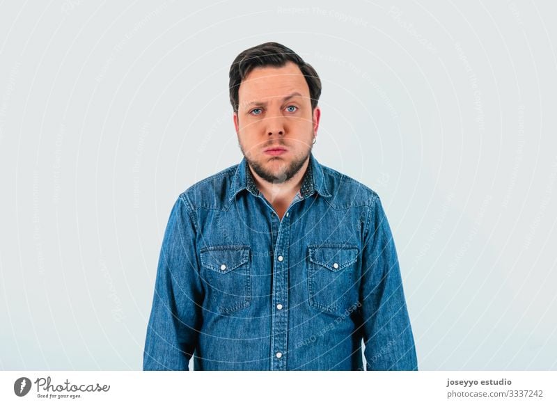 Young man with expression of tiredness and denim shirt. Isolated gray background. 30-40 years advertisement advertising apathy attitude banner beard blue eyes