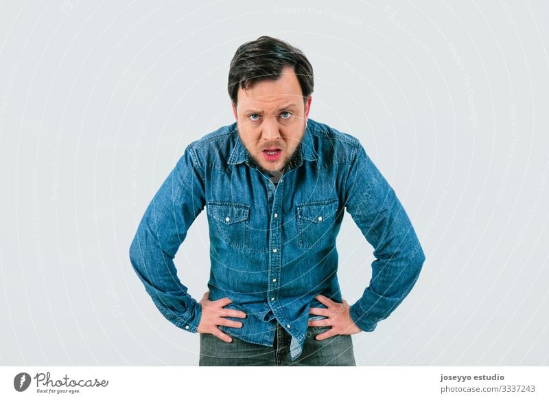 Young man with expression of tiredness and exhaustion. Denim shirt and isolated gray background. 30-40 years advertisement advertising anguish annoyance anxiety